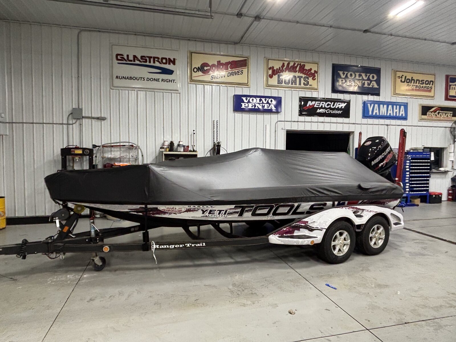 Custom charcoal fitted cover on a Ranger bass boat in an indoor showroom