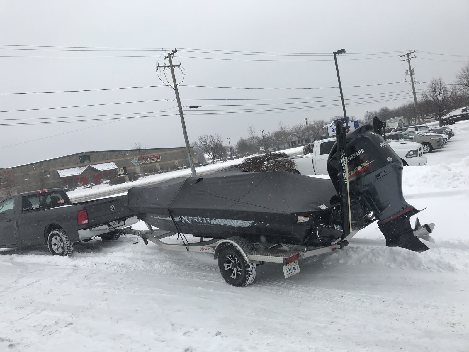 Black fitted boat cover on an Xpress boat in the snow