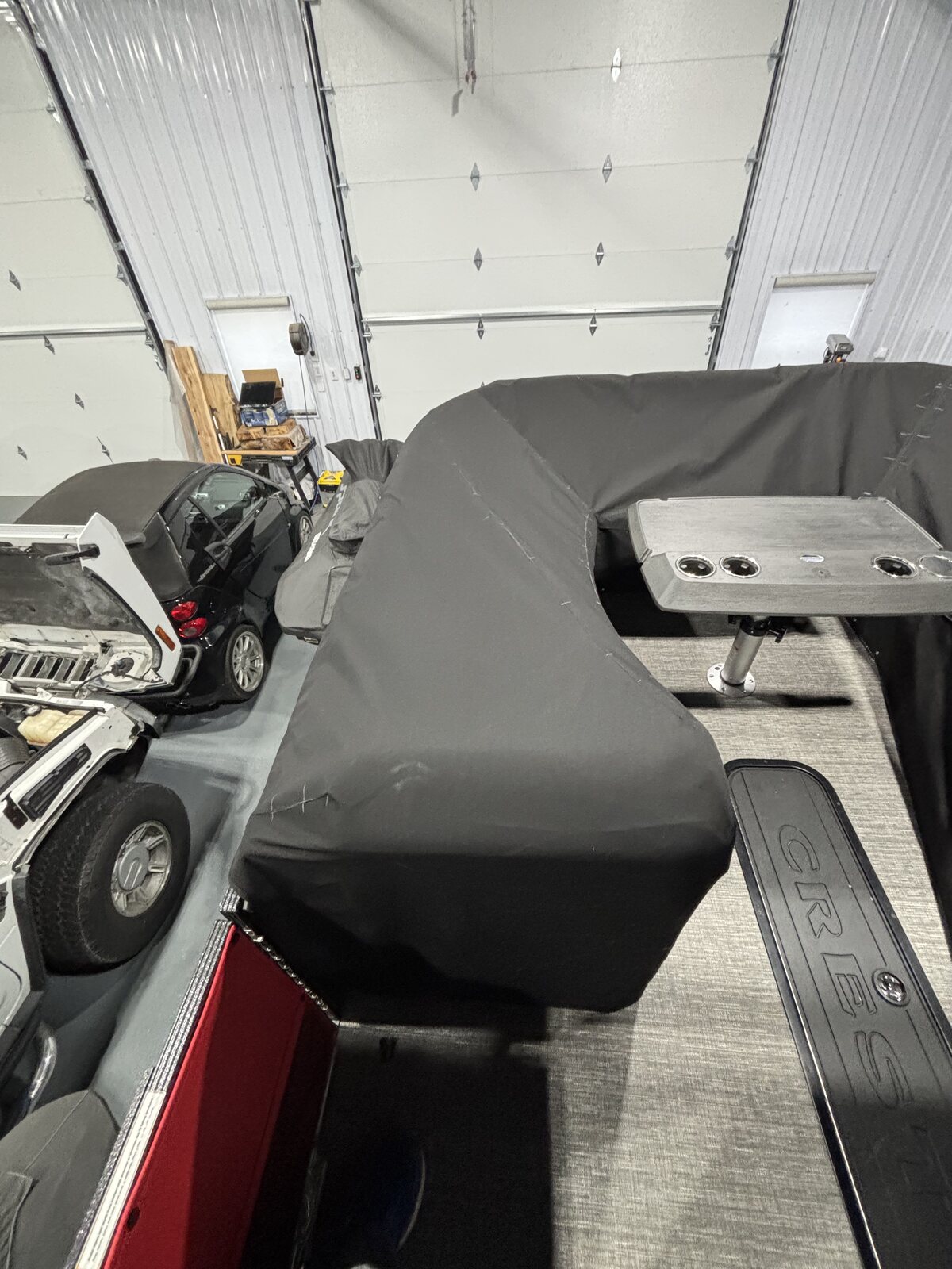 Black fitted cover on a pontoon with a red hull