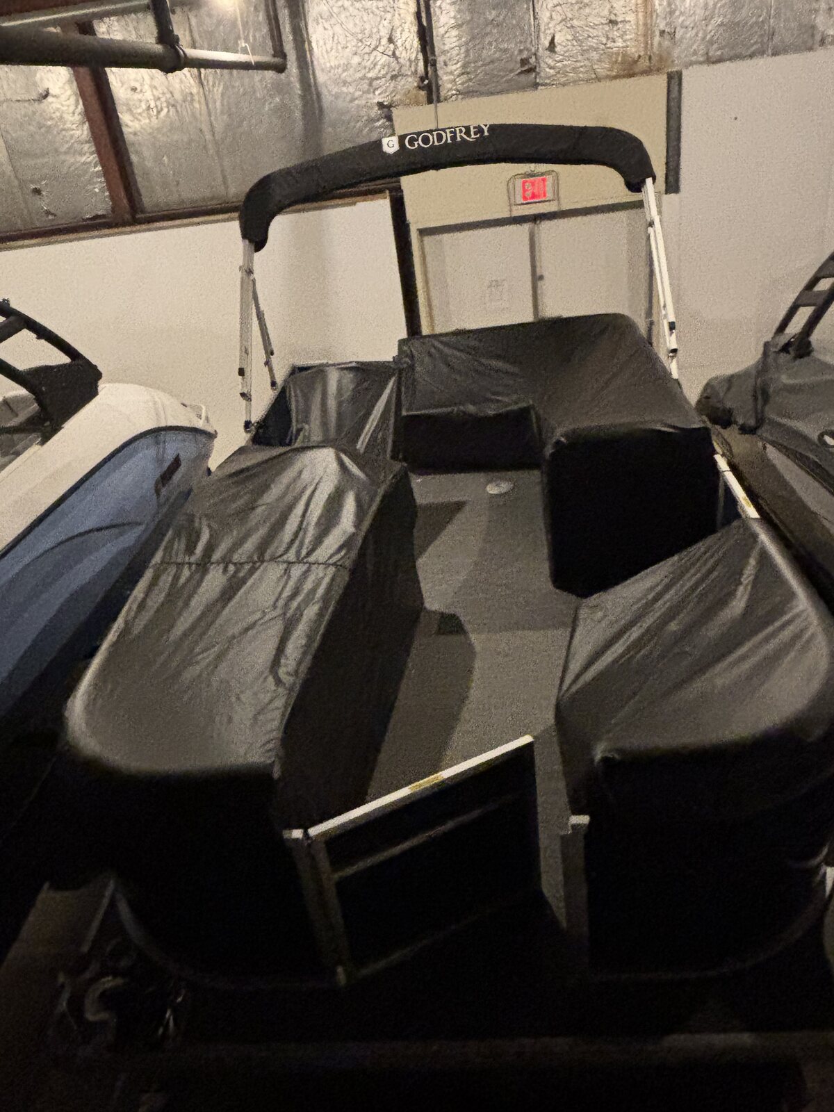Black fitted cover with bimini on a Godfrey pontoon